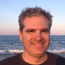 Brian Kelly, President of Sea Bright Solar, smiling by the beach with the ocean in the background