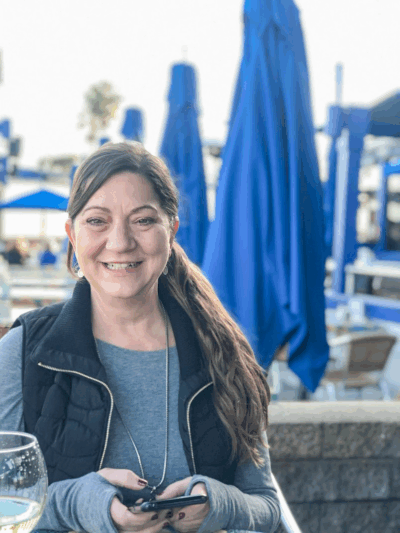 Gina Gennette, CEO of Best Payment Solutions, smiling at an outdoor café, featured guest on The Covert Code Podcast discussing family-centered business and prepaid payment innovation.
